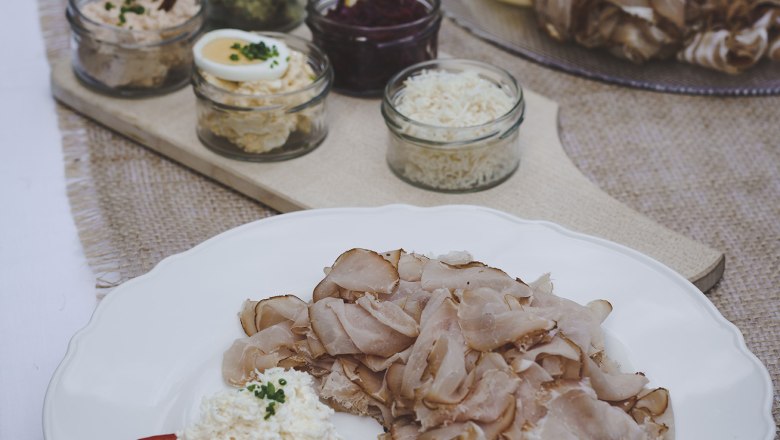 TDR snack, © Buschenschank Buder A plate with cold cuts and side dishes on a table.