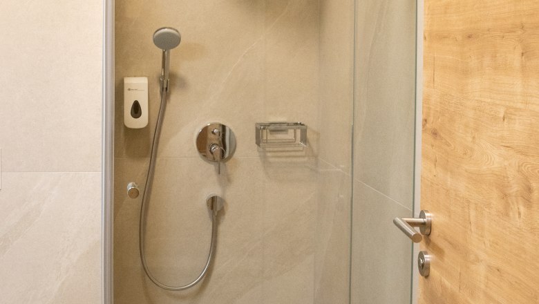 Bathroom with shower, © Nadine Beles Modern bathroom with glass shower, shower head and wooden details.