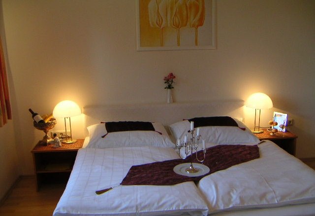 Exterior view of Weinpension Andrea, © Weinpension Adrea Sooss Cozy bedroom with double bed, bedside tables and lamps.