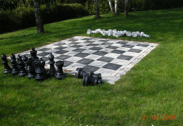 Chessboard, © Gemeinde Eichgraben Large outdoor chessboard with black and white pieces on a meadow.
