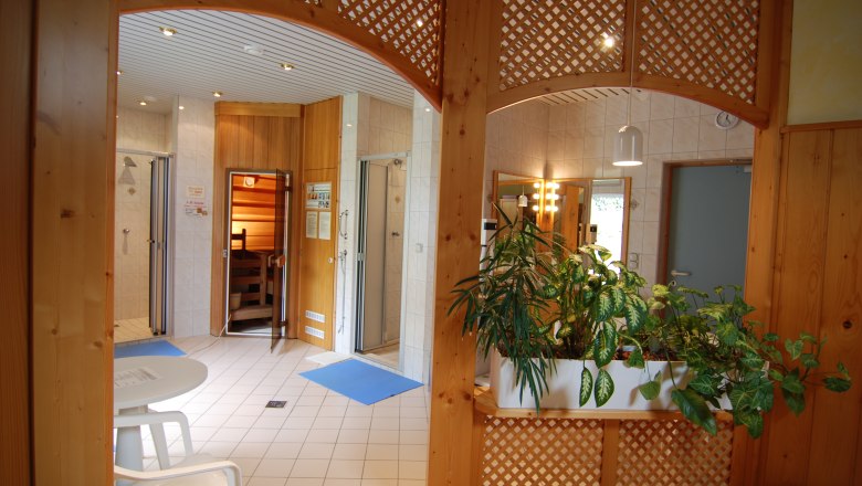 Feel-good oasis, © Gasthof Nordwald Interior view of a wellness area with sauna, plants and seating area.
