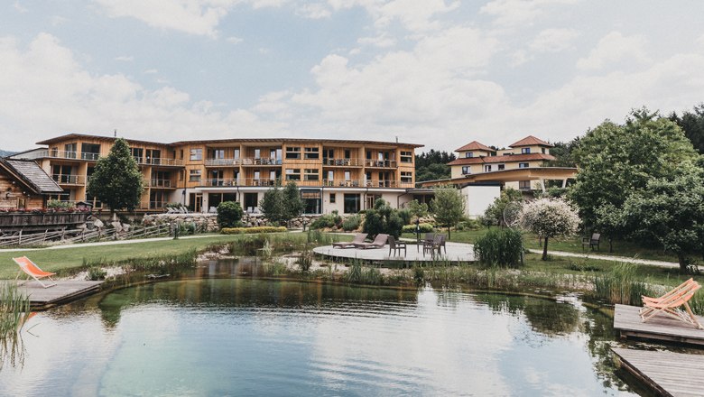 Delicacies from the kitchen, © Heldentheater, Hotel Molzbachhhof Hotel building with natural pond and sun loungers in the foreground.