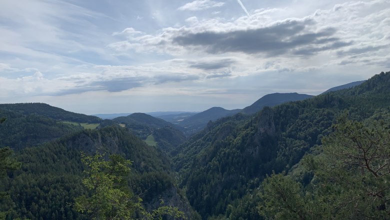 Semmering view Weinzettlwand, © Tourismusverband Semmering-Rax-Schneeberg View of wooded mountains and valleys under a cloudy sky.