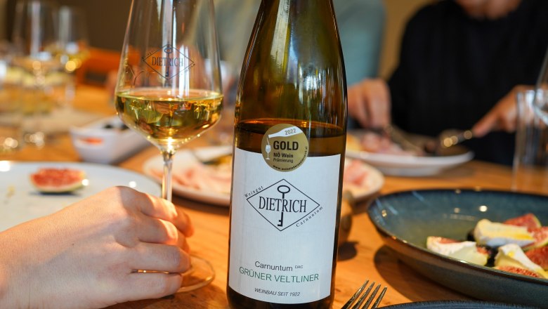 Winery Claus Dietrich, © Marktgemeinde Petronell-Carnuntum, marketing circus Wine bottle and wine glass at a laid table with food