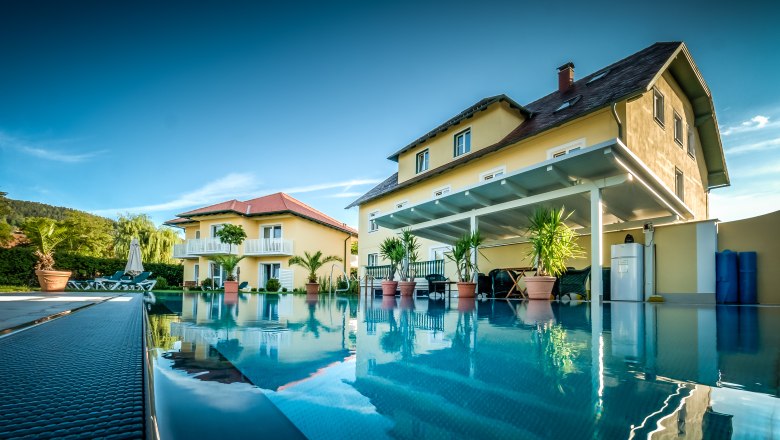 Garden villa with pool, © Photography Pfeffel The garden villa with large pool in the foreground, surrounded by plants and sun loungers.