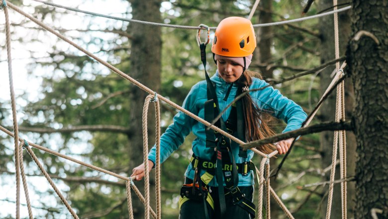 Hirschenkogel forest ropes course Semmering, © Semmering-Hirschenkogel Child with helmet on rope bridge in climbing park.