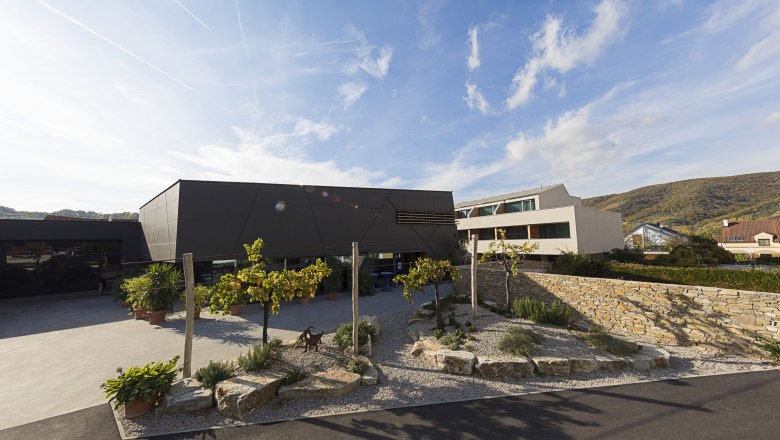 Wine lodge access, © Weinlodge Siedler Modern building with garden and stone wall in the foreground.