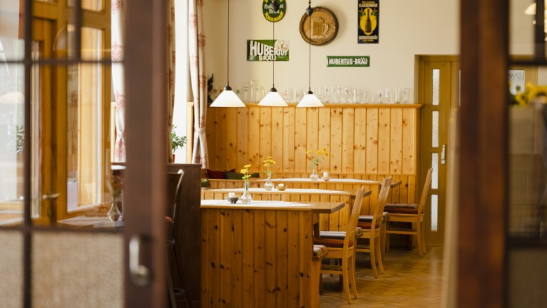 Typical Weinviertel pub culture, © Niederösterreich Werbung/Michael Reidinger Interior view of a traditional Austrian inn with wooden furniture and decorations on the walls.