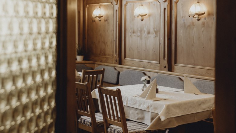 An original ambience in the interior, © Niederösterreich Werbung/Sophie Menegaldo Cozy dining room with wooden furniture and table decorations.