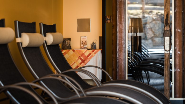 Sunny courtyard, © Wiener Alpen/Christian Kremsl Interior view of a relaxation room with deckchairs and a table with tablecloth.