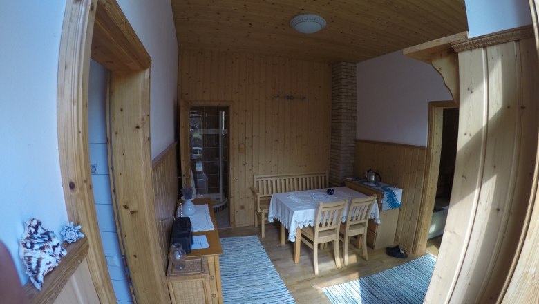 Dining room vacation apartment 2, © dmgrauszer Dining room with wooden walls, table and chairs, carpets and decorations.