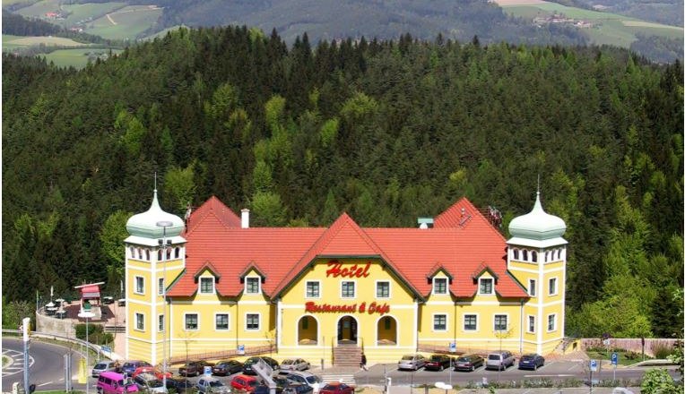 Zöbern highway restaurant and motor hotel, © Autobahnrestaurant und Motorhotel Zöbern/Anton Plank Yellow hotel with red roofs in a green, hilly landscape.