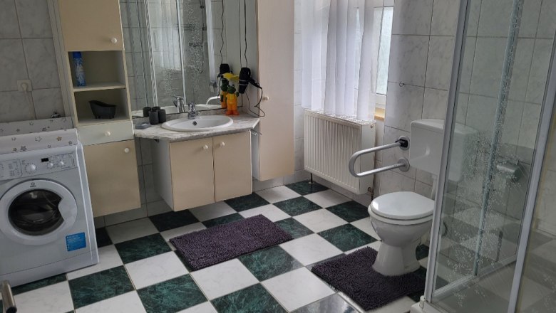 Vacation apartment Eva bathroom, © Leo-Hof/Sandra Reinisch Bathroom with washing machine, shower, toilet and washbasin. Checkerboard tiles and white curtains.