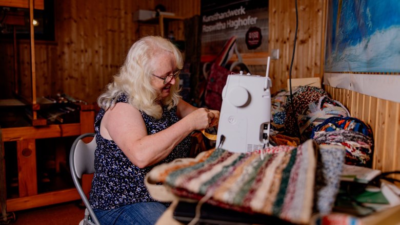 Arts and crafts Roswitha Haghofer, © Waldviertel Tourismus, Matthias Streibel A woman sews on a sewing machine in a craft studio.