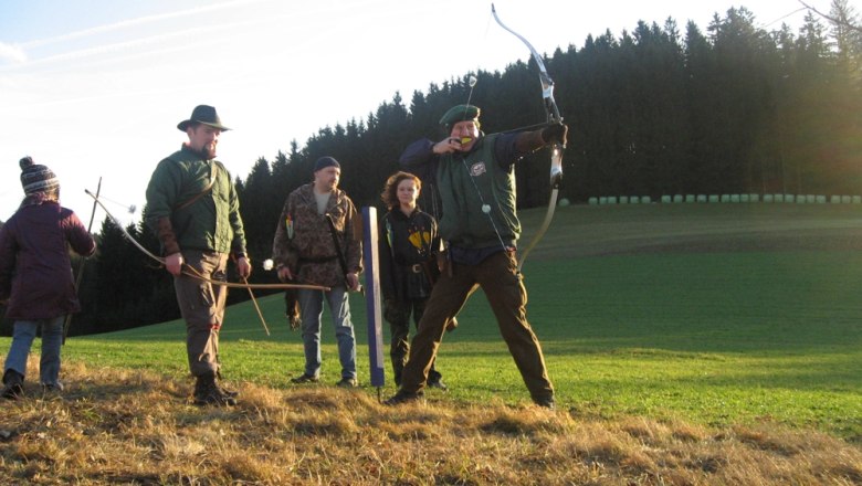 Archery, © Buchinger Group of people doing archery in a meadow in front of a forest.