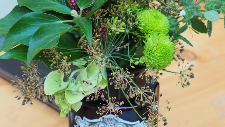 Pharmacy container, © Landschaftsapotheke Melk A pharmacy jar with the inscription 'RAD. RHEI PULV.' filled with flowers and berries on a wooden table.