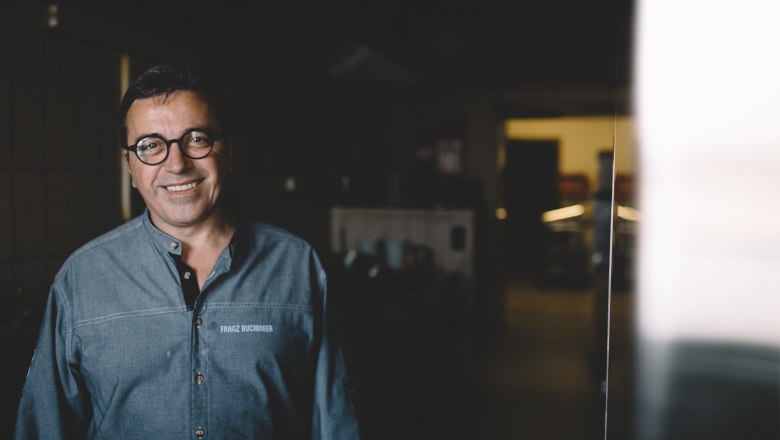 In the kitchen: host Franz Buchinger, © Niederösterreich Werbung/Mara Hohla A man in a kitchen, smiling, with glasses and a gray shirt.