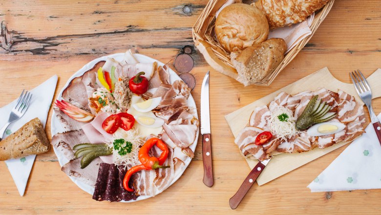 Wine & snack, © Martina Siebenhandl Board with cold cuts, vegetables and bread on a wooden table.