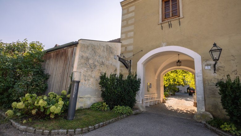Oberstockstall Estate, © Niederösterreich Werbung / Maximilian Pawlikowsky Entrance gate to Oberstockstall Estate with plants and lantern.