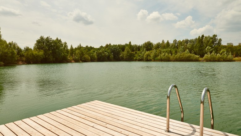 Swimming pond Persenbeug - Gottsdorf, © Klaus Engelmayer Wooden footbridge with ladder at the Persenbeug-Gottsdorf bathing pond, surrounded by trees.