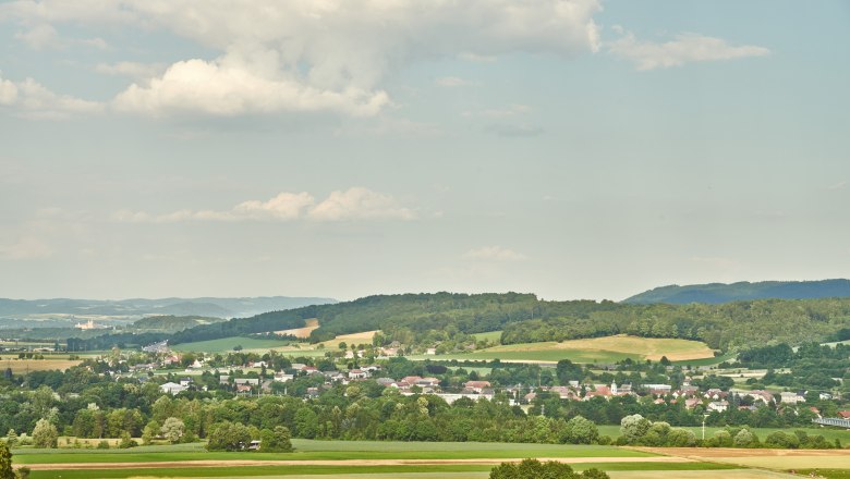 Municipality of Erlauf, © Klaus Engelmayer Landscape with fields, hills and a village in the background under a cloudy sky.