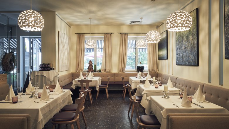 Gourmet restaurant in the middle of the Rohrwald in the district of Korneuburg, © Niederösterreich Werbung/Andreas Hofer Elegant restaurant with laid tables, modern lamps and art on the walls.