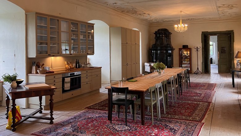 Dining room, © Schloss Haggenberg Elegant dining room with long wooden table, chandeliers and antique stove.