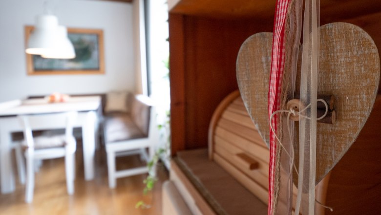 Cozy eat-in kitchen, © Doris Eminger Cozy eat-in kitchen with wooden furniture and heart decoration.