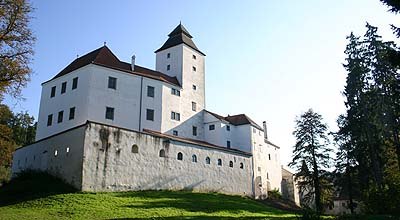 Seisenegg Castle, © zVg Seisenegg Castle with white façade and tower, surrounded by trees.