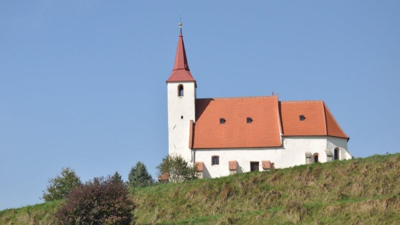Ofenbach parish church, © Thermengemeinden Ofenbach parish church on a hill with a blue sky in the background.