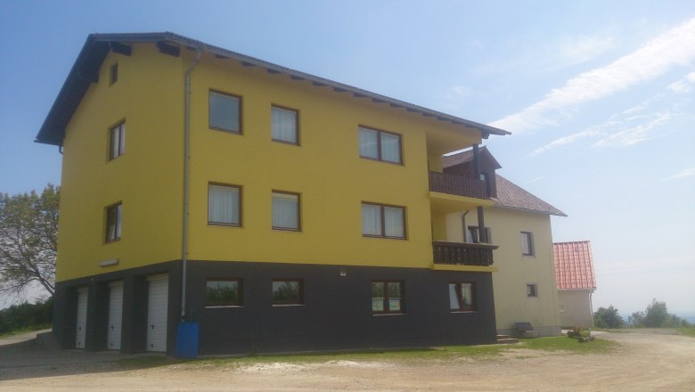 Anke's vacation apartment, © Anke Spreitzer Yellow building with several windows and balconies, blue sky in the background.