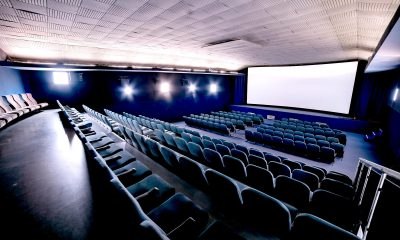 Cinema Ternitz, © Picalek Interior view of an empty movie theater with blue seats and a large screen.