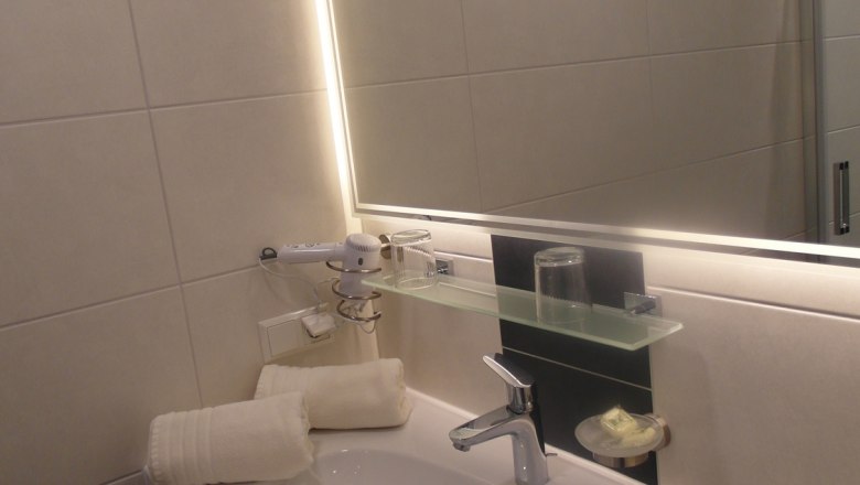 Bathroom at the Lugerhof, © Lugerhof Modern bathroom with washbasin, mirror and towels.