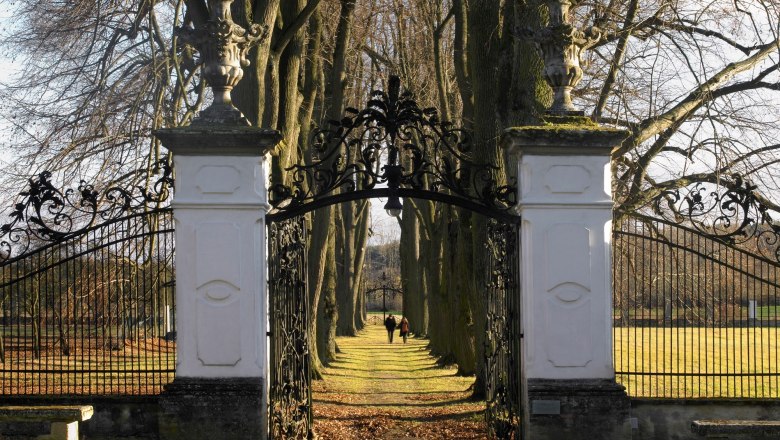 greillenstein_0088__c_nature_in_the_garden-alexander_haiden_small_1, © Natur im Garten/Alexander Haiden Iron gate with white pillars, behind it an avenue with trees.