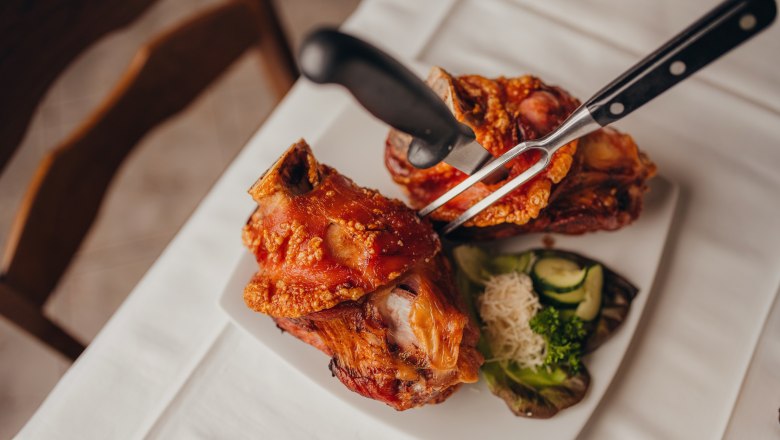 Also popular: the pig's stilts, © Niederösterreich Werbung/Daniela Führer Two pork knuckles on a plate with side dishes.