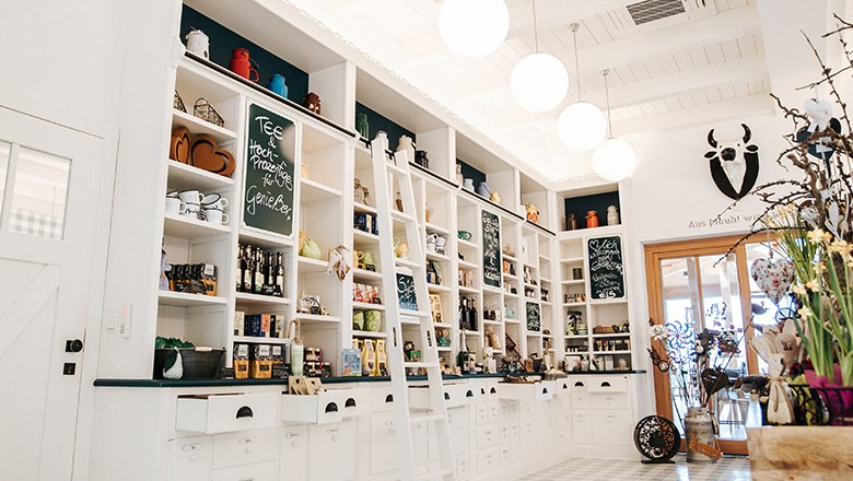 Eis-Greissler farm store inside, © Blochberger Eisproduktion GmbH Farm store with white shelves filled with various products and decorations.