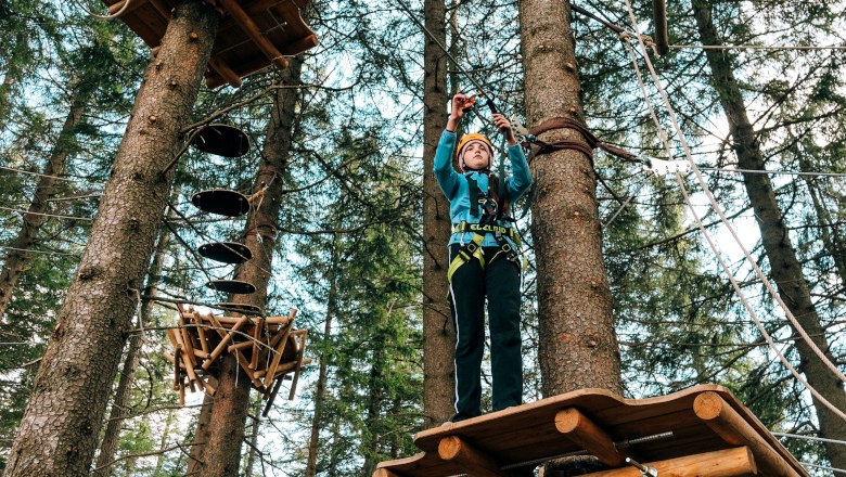 Hirschenkogel forest ropes course Semmering, © Semmering-Hirschenkogel Person in climbing park on platform between trees.