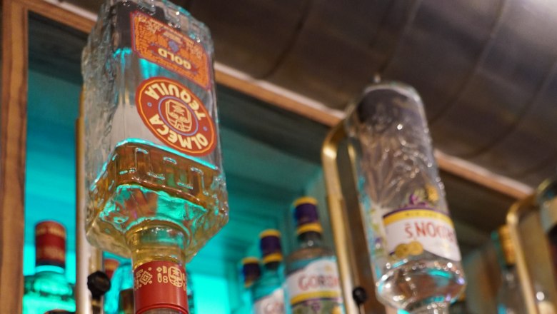 Café Leopold Schwechat, © Café Leopold Close-up of bottles of spirits in a bar with taps.