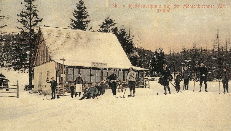 Winter sports resort with history, © Berggasthof Mönichkirchner Schwaig Historical postcard of a ski resort with people on skis in front of a hut in the snow.