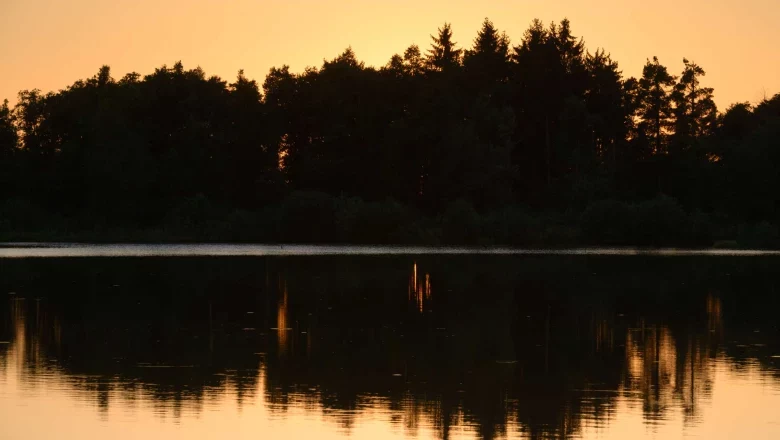 Ottenstein pond plate, © Matthias Schickhofer Sunset over a lake with trees in the background and their reflection in the water.