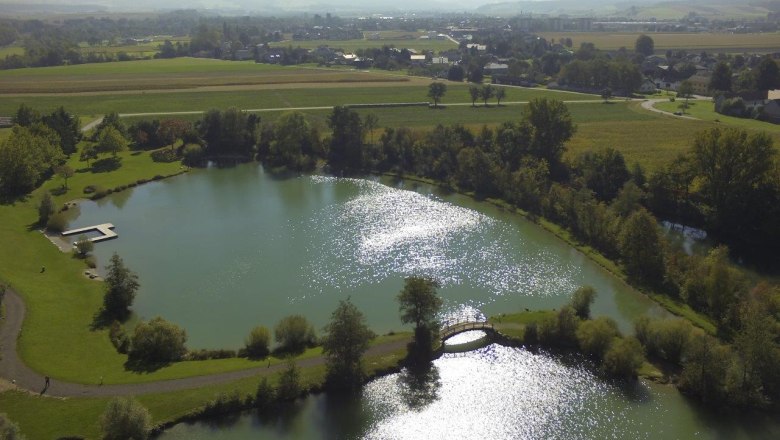 Lake Ebersdorf, © zVg Gemeinde Ober-Grafendorf Aerial view of Lake Ebersdorf with surrounding landscape.