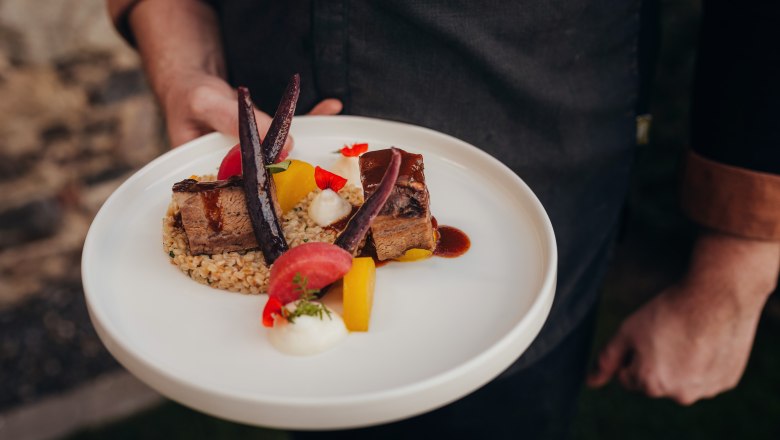Braised pastries, cider sauce, einkorn risotto, potato mousse, turnip variation, © Niederösterreich Werbung/Daniela Führer A plate of braised meat, einkorn risotto, potato mousse and turnip variation.