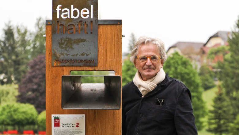 Fabulous signs in the Bucklige Welt, © Nikolaus Pfusterschmid A man stands next to a wooden sign with the words 'fabulous' in a park.