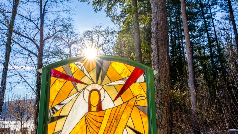 Tiffany glass panel at the Glass Way of the Cross in winter, © Wiener Alpen, Flotoanker - Luckerbauer Stained glass window illuminated by the sun in the forest