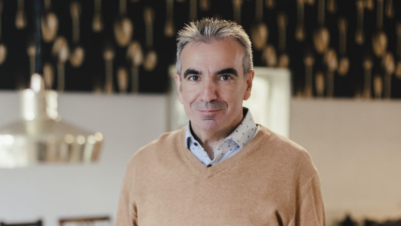 Host and sommelier Martin Blauensteiner, © Niederösterreich Werbung/David Schreiber A man in a restaurant holds a plate of food in his hand.