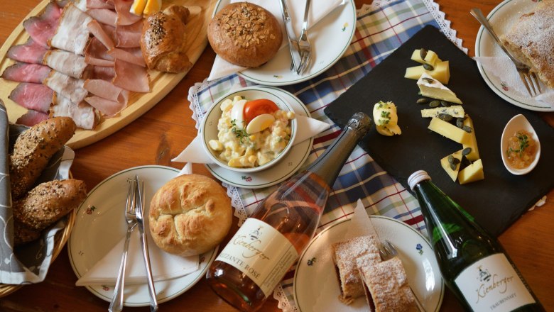 Snack, © Sophie Kienberger A table with a selection of cold meats, cheese, bread, salad and drinks.