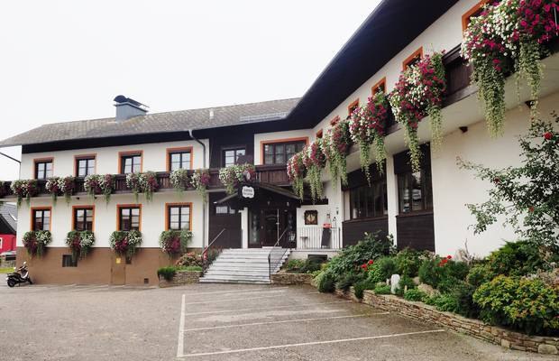 Country inn Lechner, © Landgasthof Lechner A traditional country inn with balconies decorated with flowers and an entrance with stairs.