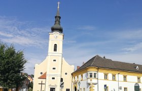 Parish church with vicarage, © Roman Zöchlinger Parish church with tower and adjoining vicarage under a clear sky.