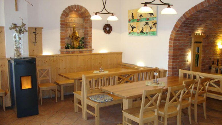 Wine tavern, © Ötl Cozy interior of a wine tavern with wooden furniture and brick arches.