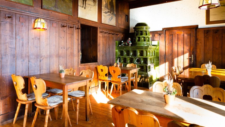 Ottohaus - Restaurant, © Katrin Nusterer Cozy dining room with wooden furniture and green tiled stove.